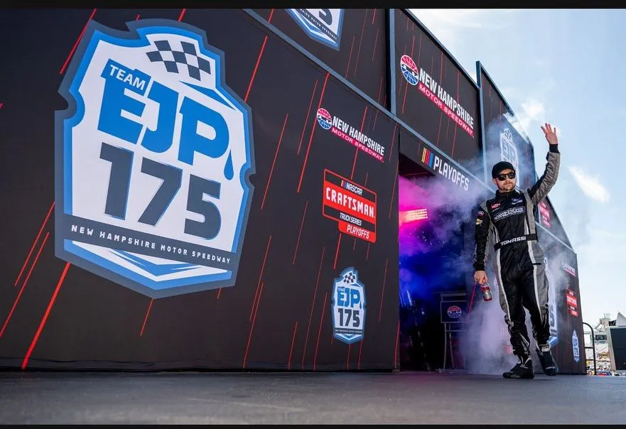 Tyler Tomassi exiting the tunnel in his branded racing suit as the crowd watches