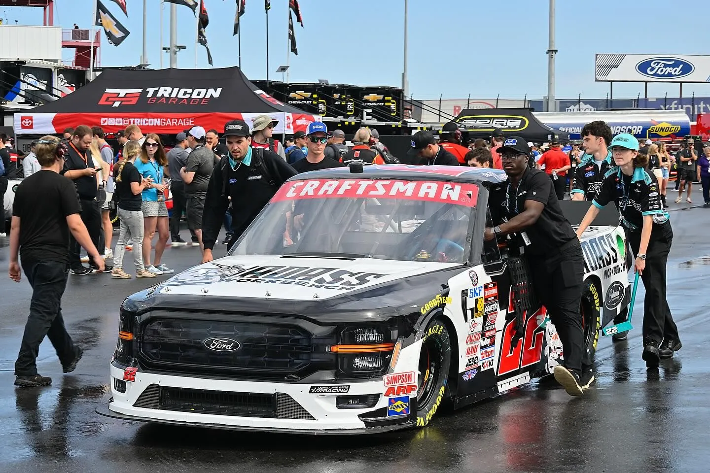 Pit crew preparing a branded race truck before the race